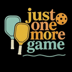 Op de afbeelding: Retro-afbeelding op een zwarte achtergrond met de tekst "just one more game" in oranje, geel en teal. De afbeelding bevat ook twee pickleball rackets en een bal.