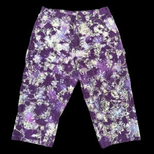 Hand-dyed long shorts created from reworked double-knee pants. Reverse tie-dyed, hemmed, and uniquely colored one-of-a-kind wear. Size 33W