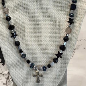 Black beaded necklace with silver accents and black crystal cross pendant. 22&quot; length
