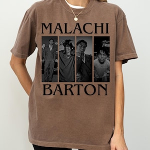 May include: Brown t-shirt with a black and white image of a person in four poses. The name "MALACHI" is printed above the image, and "BARTON" is printed below it in black block letters. The shirt is worn by a person.