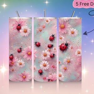 May include: Three stainless steel tumblers with lids and straws. The tumblers feature a design of red ladybugs, pink flowers, and white daisies on a pastel pink and blue background with gold glitter accents. The text "5 Free Designs" is in the upper right corner.