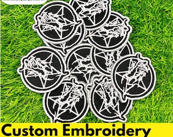 May include: A pile of black and white custom embroidery patches. Each patch has a circular design with a pentagram and a detailed illustration. The patches are arranged on green grass. The text "Custom Embroidery Patches" is displayed.