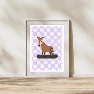 May include: A framed art print featuring a brown okapi riding a black skateboard. The okapi has zebra-like stripes on its legs. The background is a checkered pattern in shades of purple and white. The frame is white.
