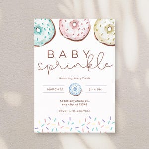 May include: A baby sprinkle invitation with watercolor donuts in blue, pink, and yellow. The invitation includes the text "BABY sprinkle" in a handwritten font, along with the date, time, and RSVP information.