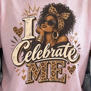 Può includere: Una t-shirt rosa chiaro con la grafica di una persona dai capelli scuri e ricci che indossa un foulard leopardato e occhiali da sole. Il testo I Celebrate ME è scritto in un carattere stilizzato con accenti leopardati e cuori.