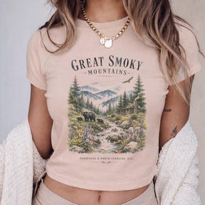 Great Smoky Mountains t-shirt with bear cubs and cabin in a woodland scene.