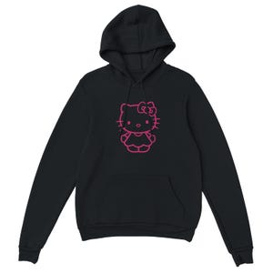 May include: Black hooded sweatshirt featuring a pink outline of a cartoon character. The sweatshirt has a front pocket and a drawstring hood. The graphic is centered on the chest.