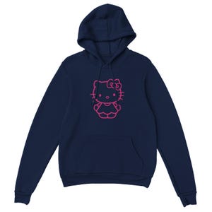 May include: Navy blue hoodie featuring a pink outline of a cartoon cat character. The hoodie has a drawstring hood and a kangaroo pocket. The cat character has a bow and is wearing a dress. The hoodie is made of a soft material.