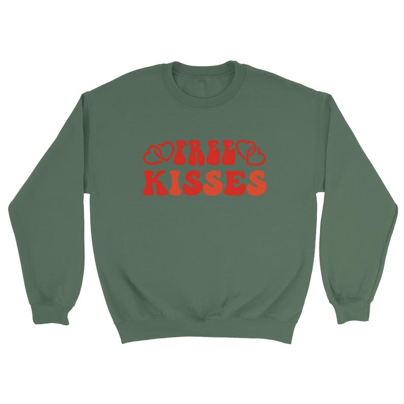 May include: A green sweatshirt featuring the text "IRISH KISSES" in red and orange. The lettering has a retro design. The sweatshirt has a crew neck and is a solid colour.