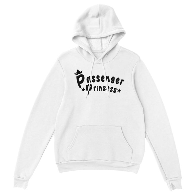 May include: White hooded sweatshirt with a front pocket and a drawstring hood. The black text on the front reads "Passenger Prinssss" with a crown and star accents. A casual, comfortable garment.