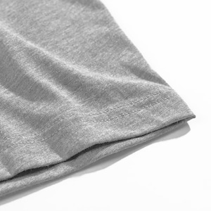 Op de afbeelding: Close-up van een grijze t-shirtmouw. De stof is een zacht, gem&ecirc;leerd grijs, met zichtbare textuur. De zoom is netjes gestikt met een dubbele rij draad.