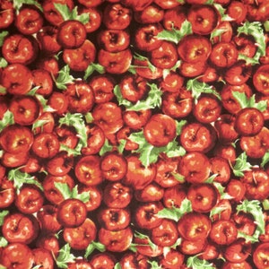 May include: A close-up image of a fabric with a repeating pattern of red apples with green leaves. The apples are arranged in a random pattern and are all the same size. The fabric is ideal for crafting projects, quilting, and other sewing projects.