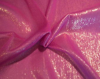 May include: Close-up of a pink iridescent fabric with a subtle shimmer. The fabric is folded and draped, showcasing its texture and sheen.