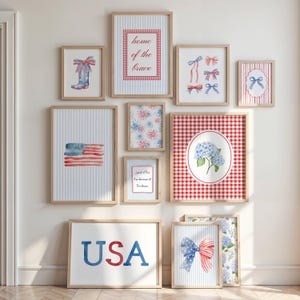 May include: A gallery wall arrangement of ten framed prints featuring patriotic themes in red, white, and blue. The collection includes watercolor illustrations of bows, a boot, fireworks, hydrangeas, the American flag, and text reading USA and home of the brave.