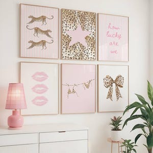 Könnte beinhalten: Eine Galeriewand mit sechs gerahmten Drucken. Die obere Reihe zeigt drei Leoparden auf rosa Streifen, einen Hintergrund mit Leopardenmuster und einem großen Stern sowie den Text how lucky are we auf rosa Streifen. Die untere Reihe zeigt drei rosa Lippen, zwei Bikinis auf einer Wäscheleine und eine Schleife mit Leopardenmuster.