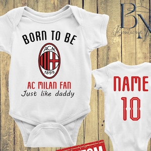 May include: Two white baby onesies. One has the text "BORN TO BE AC MILAN FAN Just like daddy" with the AC Milan logo. The other has "NAME 10" in red. A red "CUSTOM" stamp is at the bottom.