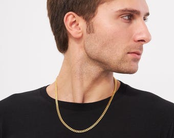 Könnte beinhalten: Eine goldfarbene Panzerketten-Halskette. Die Halskette wird von einer Person getragen, die ein schwarzes T-Shirt trägt. Die Kette hat ein klassisches Design und ist für den täglichen Gebrauch geeignet.