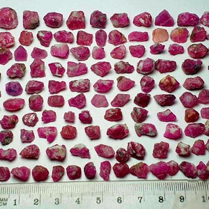 May include: A white ceramic mug with a black handle and the text "But First, Coffee" in a bold, black font. The mug is set against a blurred background, suggesting a cosy setting.