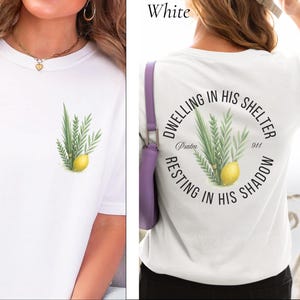 May include: White t-shirt with a watercolor illustration of a lemon and green foliage. The back of the shirt features a circular design with text that reads "Dwelling in His Shelter, Resting in His Shadow, Psalm 91:14."