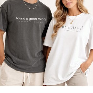 May include: Two oversized t-shirts, one charcoal gray and one white. The gray shirt has the text "found a good thing" and "Proverbs 18:22". The white shirt has the text "priceless" and "Genesis 2:18".