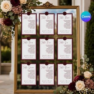 May include: A gold-framed mirror displaying nine white rectangular table seating cards with burgundy borders and wax seal accents. Each card lists table numbers from one to nine, guest names, the couple's names Sarah and Daniel, and the date 09.21.2026.
