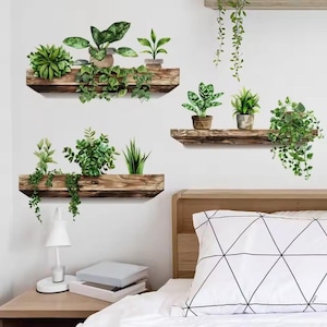 May include: Wall decals featuring watercolor illustrations of various potted plants and hanging greenery on rustic wooden shelves. The image shows three shelves with different plant arrangements, creating a natural and decorative aesthetic for interior spaces.