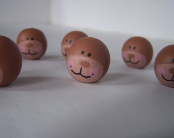 Ten wood doll heads painted faces bear or monkey