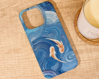 May include: A blue phone case featuring a koi fish design. The case has a wavy water pattern in shades of blue and white, with two orange and white koi fish swimming across the surface. The case is made of a durable material and is designed to protect the phone.