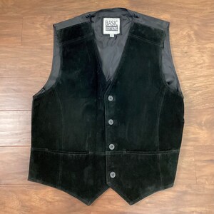 May include: A black suede vest with a button closure and a label that reads "Basic Editions".