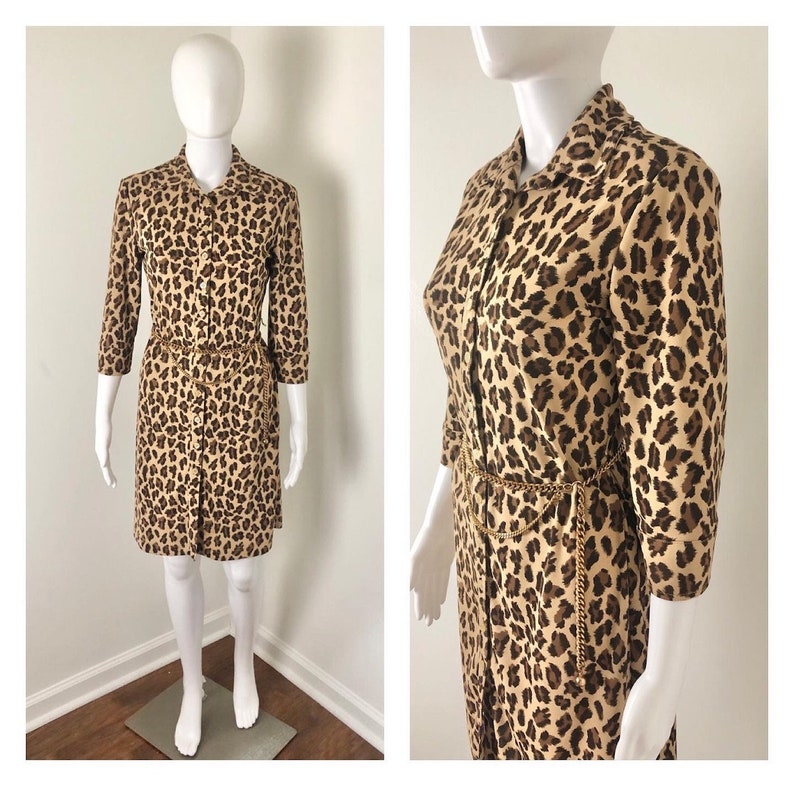 May include: A brown and black leopard print button-down dress with a gold chain belt.