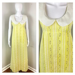 May include: A yellow maxi dress with a white Peter Pan collar and a floral print. The dress has a fitted bodice and a flowing skirt.