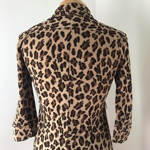 May include: A brown and black leopard print shirt with long sleeves and a button-up collar.