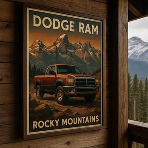 Puede incluir: Póster enmarcado que presenta una camioneta Dodge Ram en las Montañas Rocosas. La imagen muestra una camioneta naranja sobre un terreno rocoso con montañas nevadas al fondo. Las palabras "DODGE RAM" y "ROCKY MOUNTAINS" están impresas en el póster.