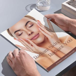 Puede incluir: Un libro titulado "Radiant Skin, Radiant You" con la cara de una mujer en la portada. El libro est&aacute; abierto por manos, con la cara de la mujer centrada, los ojos cerrados y las manos tocando suavemente su rostro. El subt&iacute;tulo dice "A Modern Guide to Skincare."