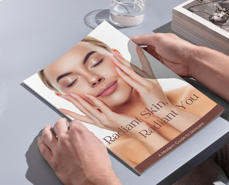 Puede incluir: Un libro titulado "Radiant Skin, Radiant You" con la cara de una mujer en la portada. El libro est&aacute; abierto por manos, con la cara de la mujer centrada, los ojos cerrados y las manos tocando suavemente su rostro. El subt&iacute;tulo dice "A Modern Guide to Skincare."
