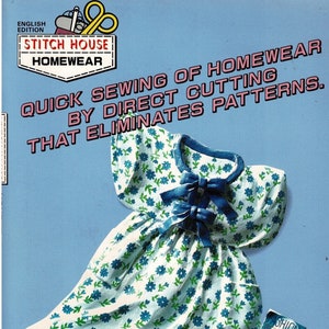 May include: A blue and white floral dress with a blue bow at the neckline. The dress is on a blue background with a red teapot and a magazine with the word "Fashion" on the cover.