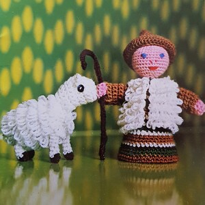 May include: A book titled "Mon Tricot Special Dolls Animals 25 Easy-To-Make Presents" with a cover image of a crocheted shepherd doll holding a stick and a crocheted lamb.