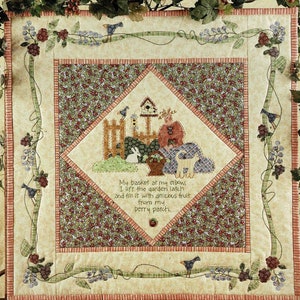 May include: A quilt pattern with a green, brown, and white floral design. The quilt is surrounded by a border of vines with berries and birds. The text "In My Berry Patch" is at the top of the quilt and the text "Art-To Heart" is at the bottom. The text "My basket at my elbow I lift the garden latch and fill it with delicious fruit from my berry patch" is in the center of the quilt.