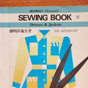 May include: A book cover with a colorful illustration of a dress and a pair of scissors. The book title is "Sewing Book" and the subtitle is "Dresses & Jackets". The book is in Japanese and English.