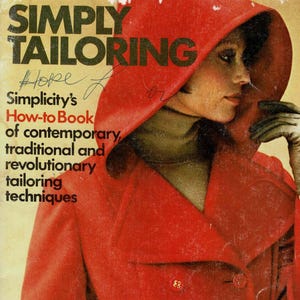 May include: A vintage instructional book titled SIMPLY TAILORING Simplicity's How-to Book of contemporary, traditional and revolutionary tailoring techniques, featuring a cover image of a red hooded coat with buttons and a brown turtleneck.