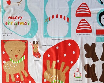 May include: A fabric panel with patterns for sewing Christmas stockings. The panel features a snowman, a reindeer, and a penguin. The panel includes instructions for sewing the stockings and the text "merry christmas" and "our little deer".