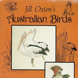 Peut inclure: Une couverture de livre illustrant des oiseaux australiens colorés. Le titre du livre est "Jill Oxton's Australian Birds" et le livre est par Allura design PTY LTD.