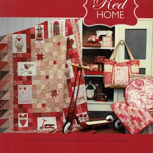 May include: A book cover titled Red HOME featuring ten red-themed sewing projects for the home by Natalie Bird. The cover displays a patchwork quilt with embroidered motifs, a red scooter, a tote bag, and various fabric items in red and white.