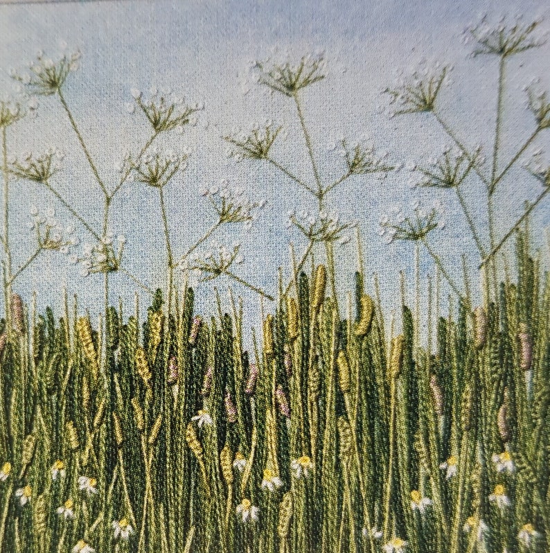Puede incluir: Obra de arte bordada que representa un campo de flores silvestres. La pieza presenta hierba verde alta, cabezas de semillas amarillas y moradas y flores blancas en forma de margarita. Delicadas flores blancas con finos tallos se extienden hacia un cielo azul claro.