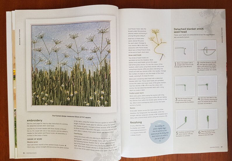 Puede incluir: Un libro abierto muestra un proyecto de bordado de una escena de pradera. El dise&ntilde;o enmarcado mide 8,5 cm cuadrados. El bordado presenta hierba verde alta, flores blancas y un fondo de cielo azul. Tambi&eacute;n se muestran instrucciones y diagramas para el bordado.