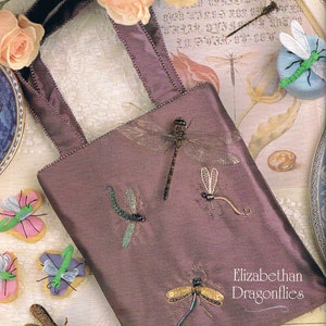 May include: A purple satin bag with beaded trim and embroidered dragonflies. The bag has two handles and is decorated with a variety of dragonfly designs. The text "Elizabethan Dragonflies" is printed on the bag.