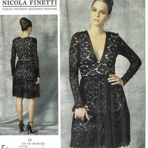 May include: A black lace dress with long sleeves and a V-neck. The dress is knee-length and features a tiered skirt. The image also shows the pattern packaging with the text "NICOLA FINETTI" and "VOGUE PATTERNS DESIGNER ORIGINAL".