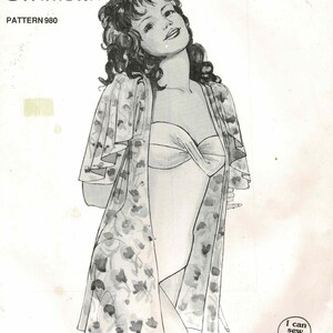 May include: Vintage sewing pattern titled "Holiday Jacket & Swimsuit" featuring an illustration of a woman in a swimsuit and floral jacket. The pattern number is 980. The Knitwit logo and the phrase "I can sew that!" are also visible.