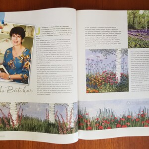 Puede incluir: Una p&aacute;gina doble de una revista con una entrevista a Jo Butcher. La p&aacute;gina izquierda tiene una foto de Jo, la p&aacute;gina derecha muestra ilustraciones florales con texto. La revista est&aacute; abierta sobre una mesa de madera.