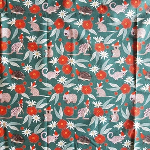 May include: A teal fabric with a repeating pattern of various Australian animals wearing Santa hats. The animals include a koala, a wombat, a kangaroo, a possum, a echidna, and a bandicoot. The fabric also features red gum blossoms and white flowers.